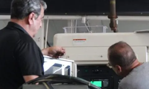 Technicians working on a Triton generator control panel